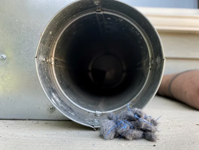 Woodcrest Dryer Vent Cleaning technician using specialized equipment to clear severe dryer vent blockage in Woodcrest